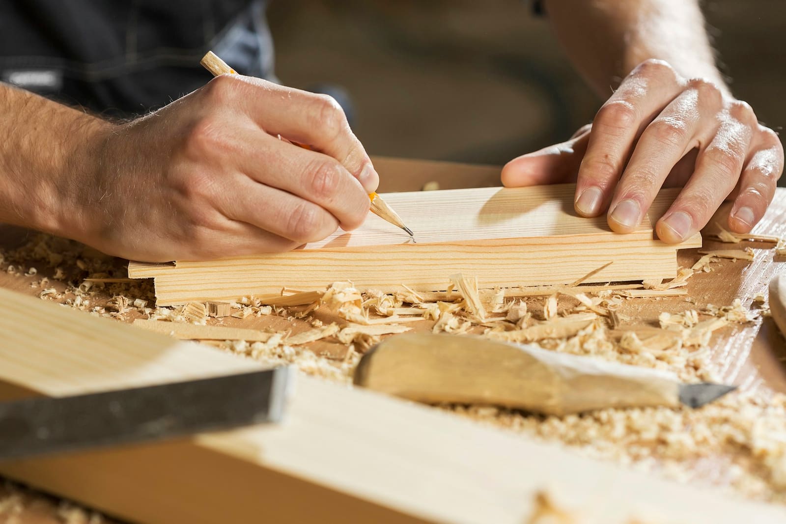 Menuisier traçant une coupe au crayon sur une planche de bois