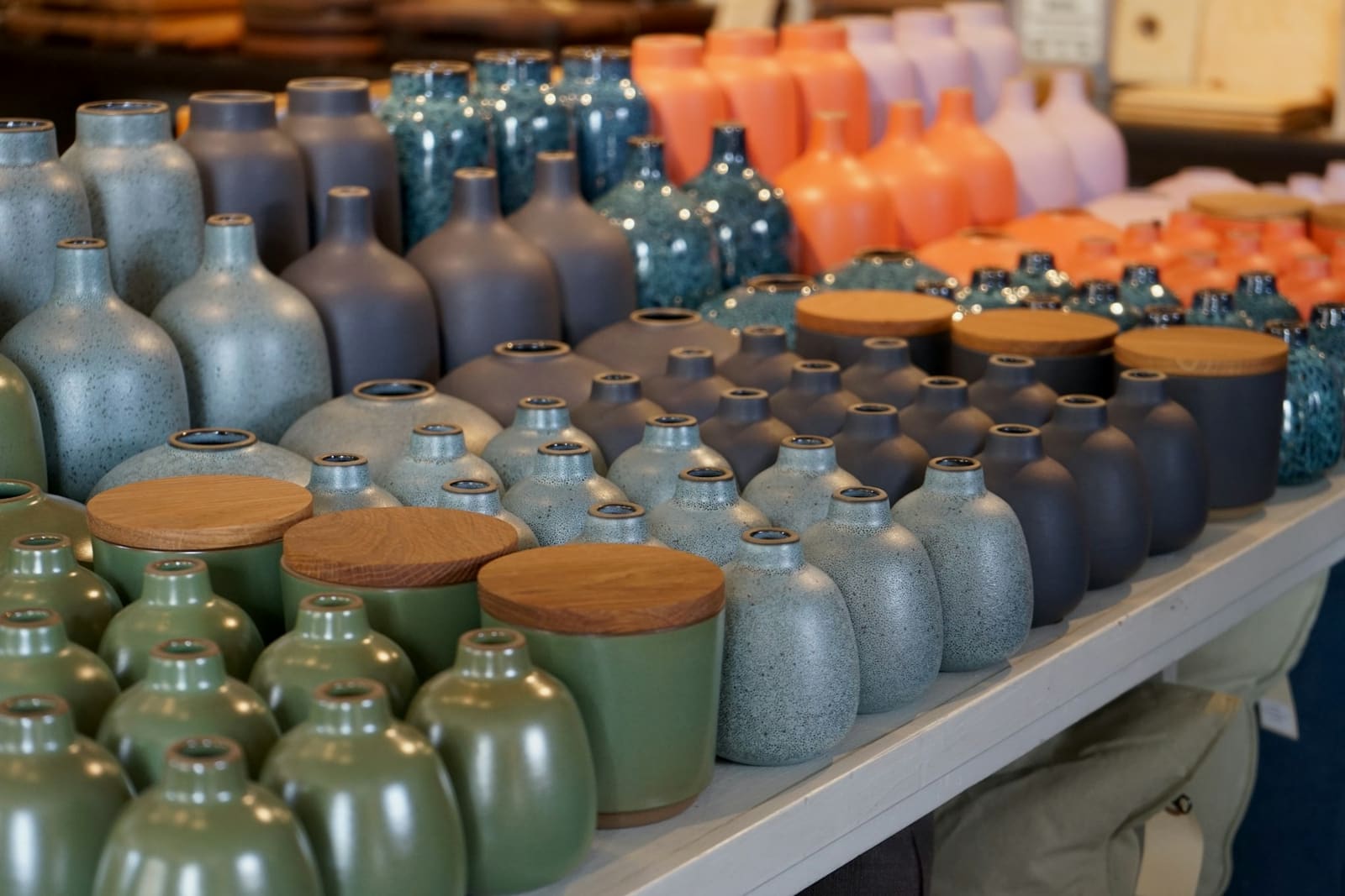 Vases colorés alignés sur une étagère