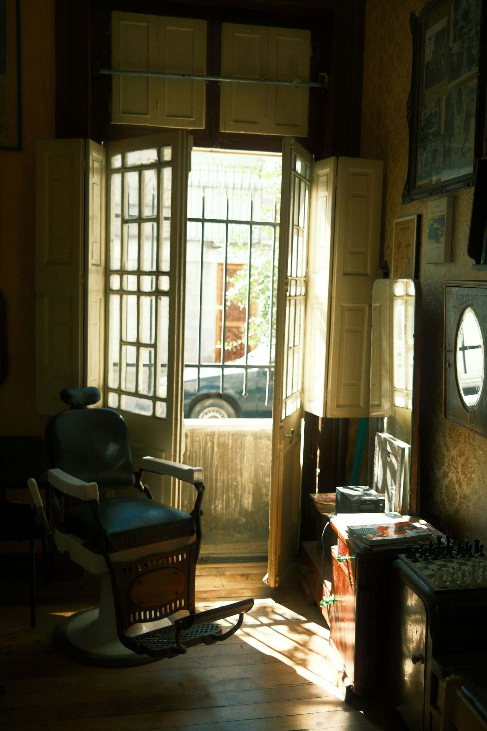 Fauteuil de barbier ancien au soleil près d'une porte vitrée