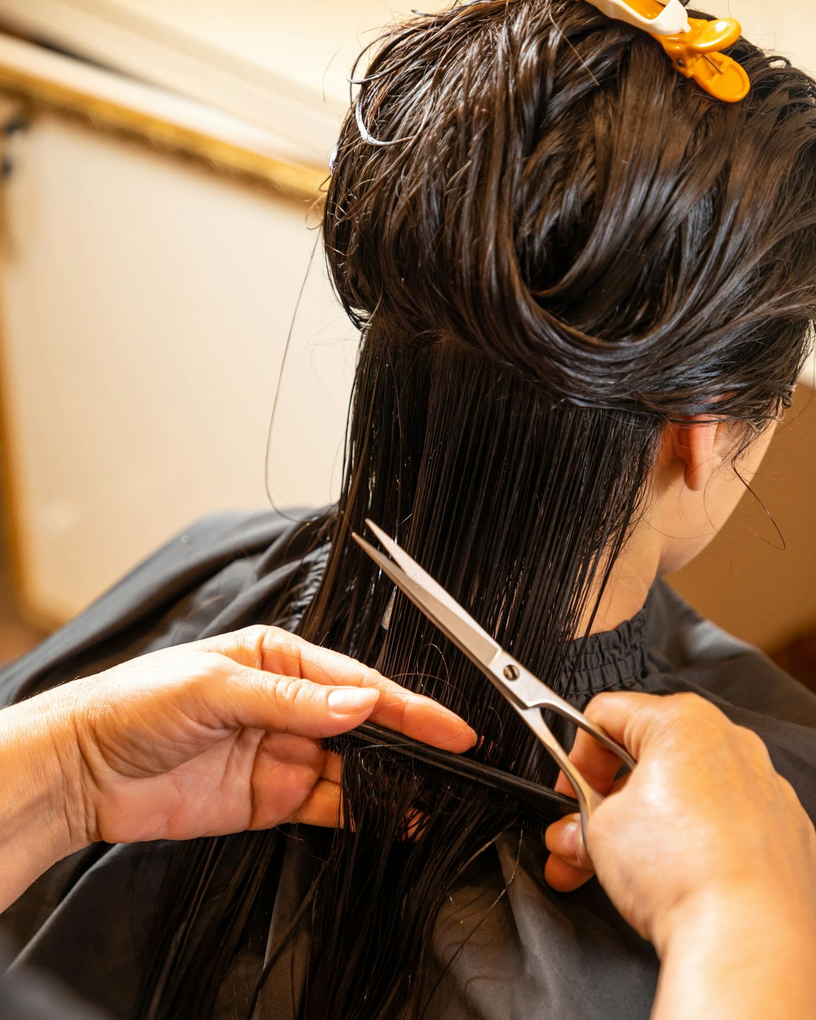 Coiffeuse coupant des cheveux longs aux ciseaux