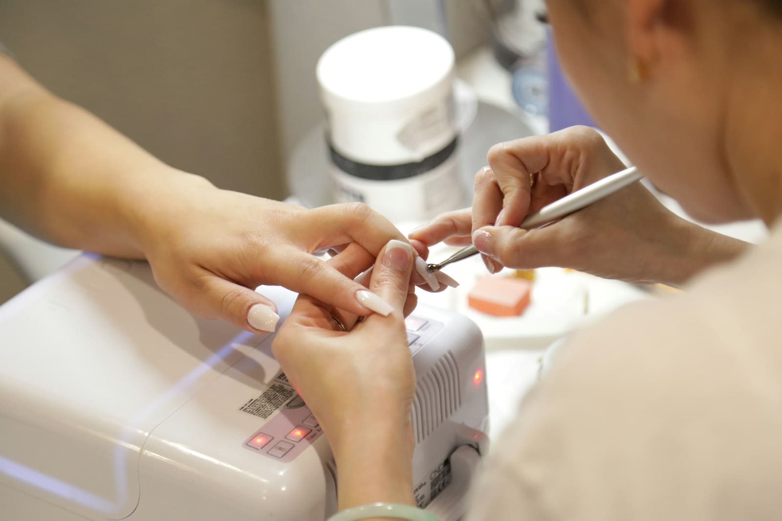 Prothésiste ongulaire posant un vernis