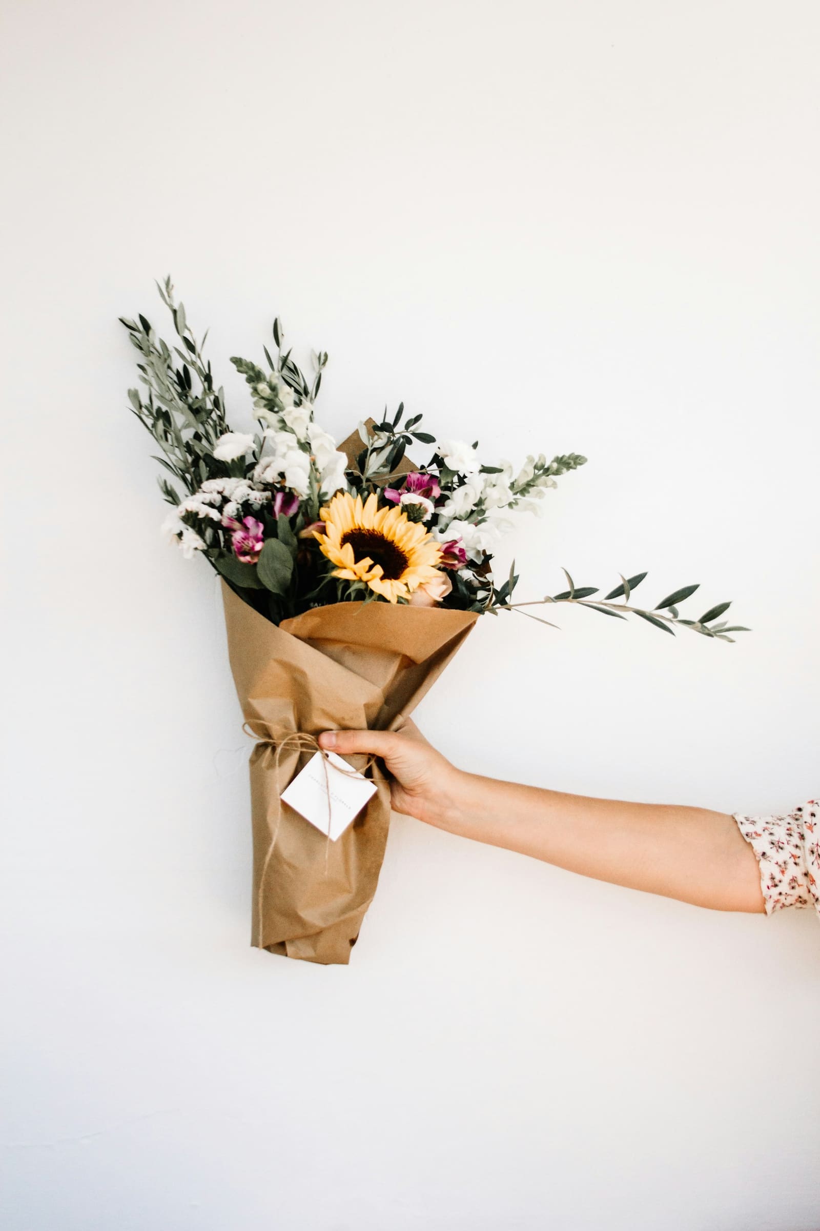 Bouquet de tournesol et feuillages emballé dans du papier kraft