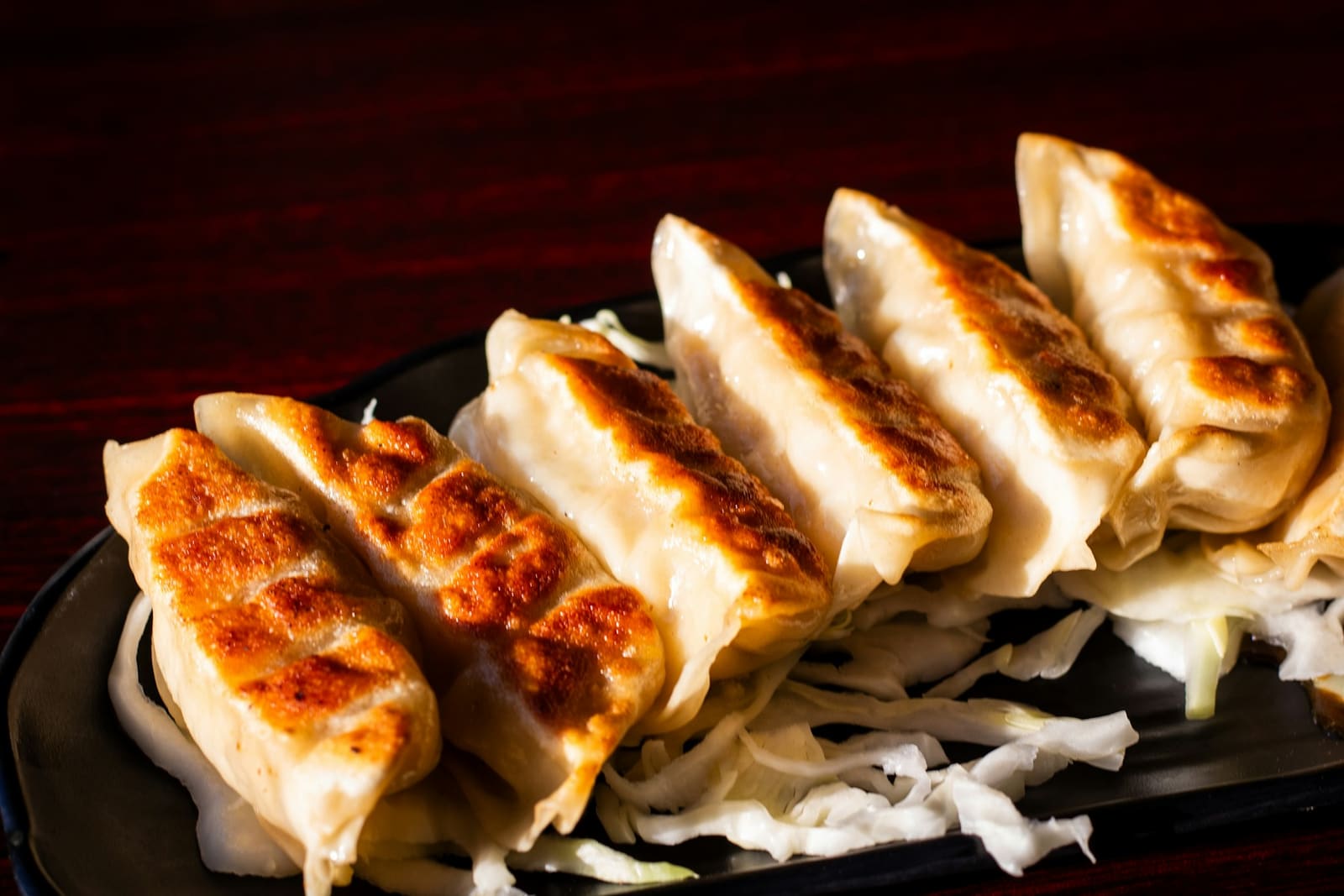 Gyoza grillés sur une assiette noire