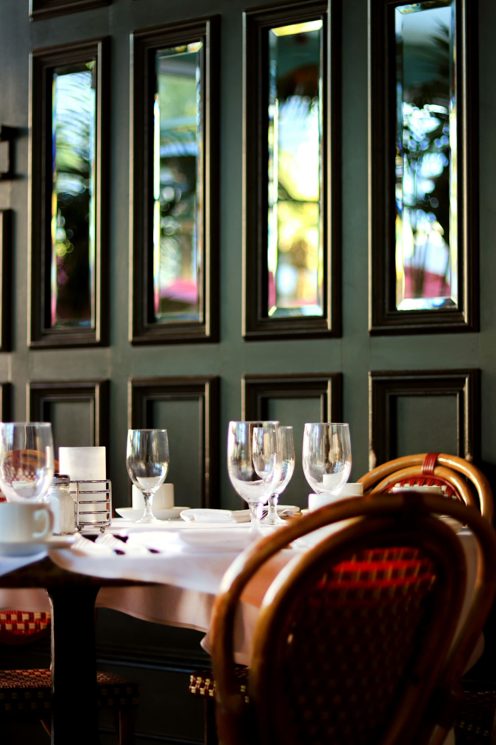 Salle du bistrot, verres et assiettes dressés sur une table