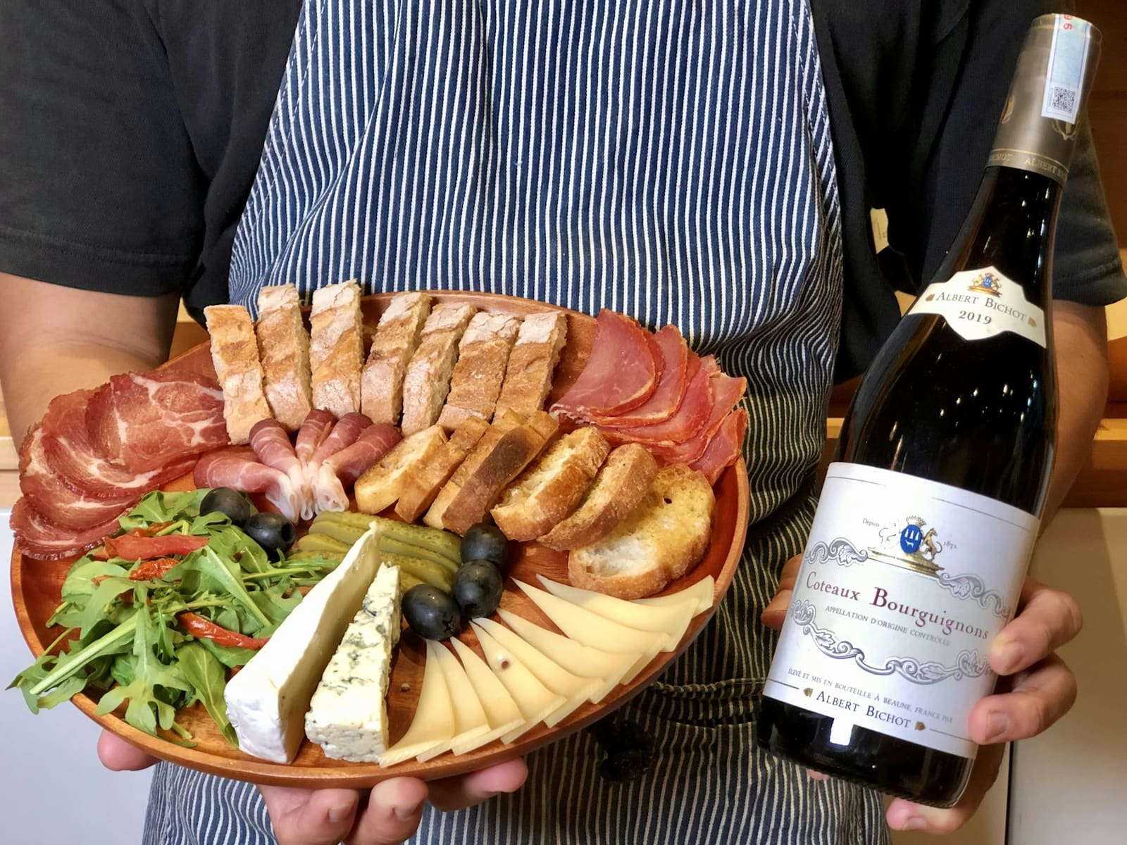 Planche de charcuterie et fromages avec une bouteille de vin